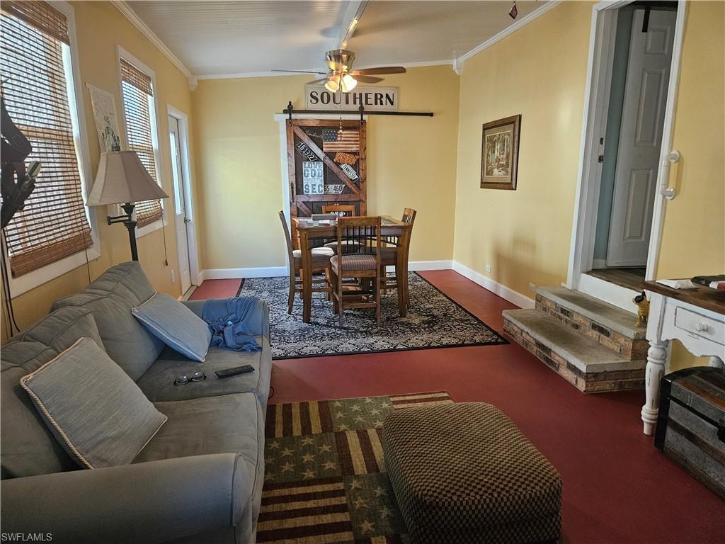 Living area with crown molding, baseboards, and ceiling fan