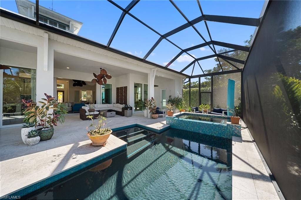 Integrated pool / hot tub with an outdoor living space, a sunroom, a lanai, and a patio area