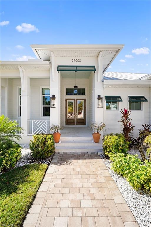 Entrance to property featuring french doors and a porch