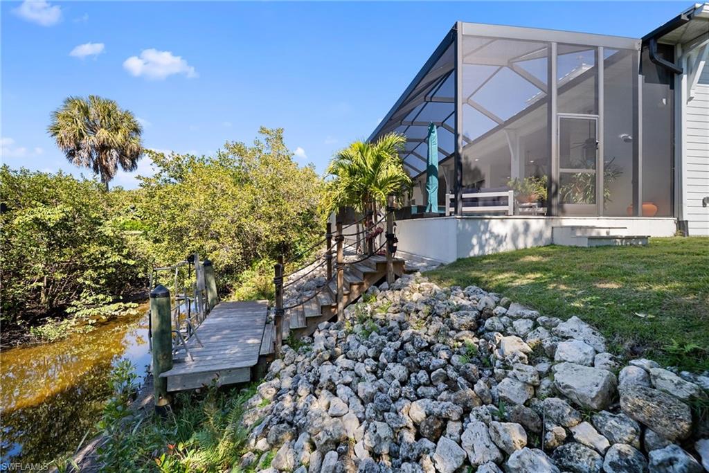 Dock with a sunroom, glass enclosure, and a lawn