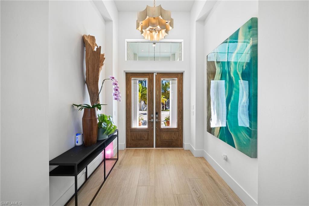 Entrance foyer with french doors, a high ceiling, and wood finished floors