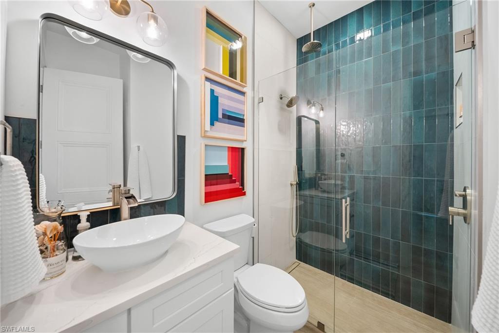 Full bath featuring a stall shower and vanity