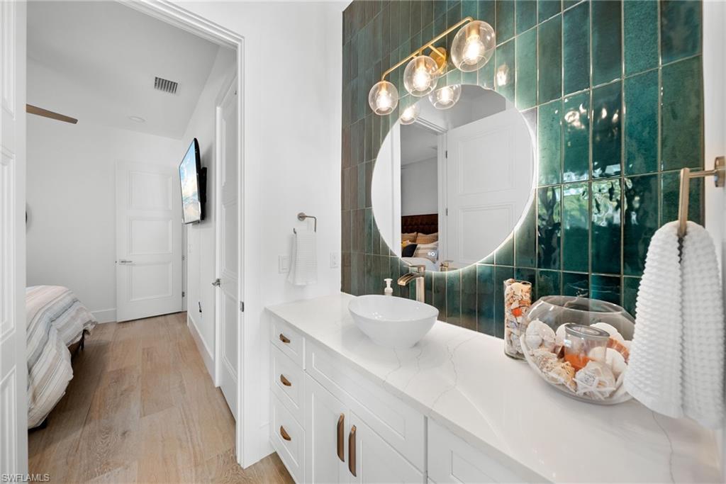 Ensuite bathroom with vanity and light wood-style floors