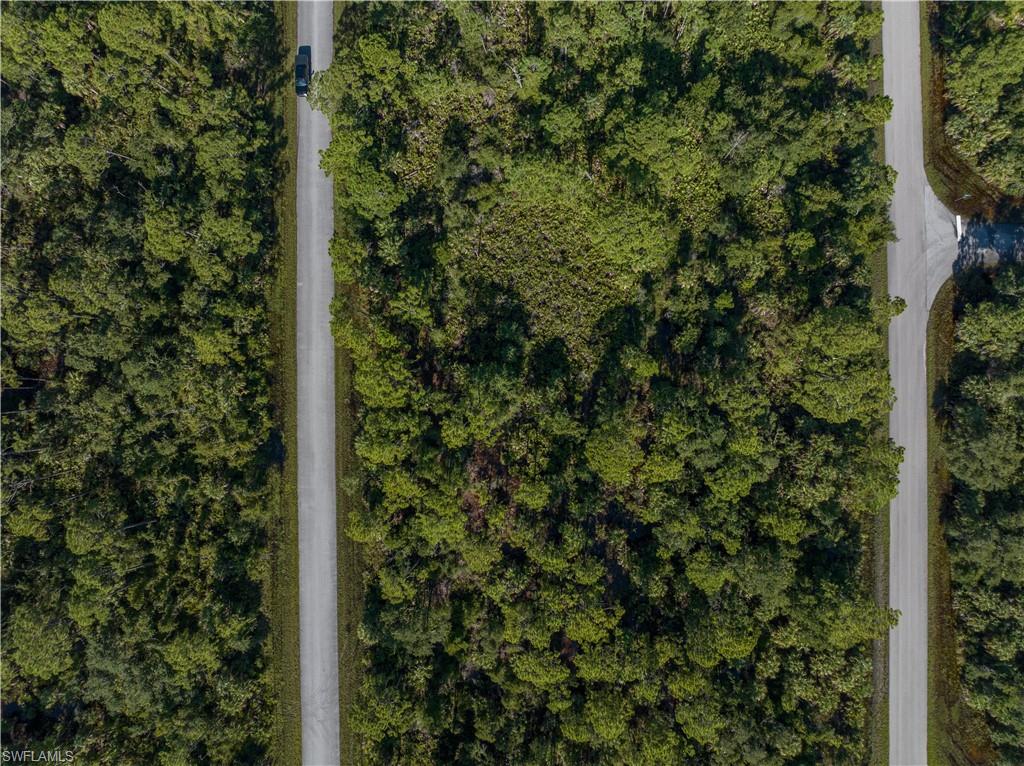 Situated in an established residential neighborhood, the lot provides privacy while remaining close to everyday conveniences. No HOA restrictions allow flexibility in design and use. Well and septic required (buyer to verify). Scrub Jay permit required prior to construction—buyer to verify status and requirements with local authorities.
