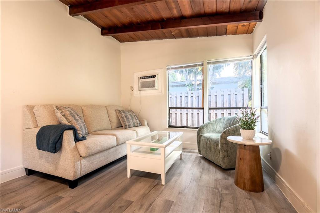 Living area featuring vaulted ceiling with beams, wood ceiling, and wood finished floors