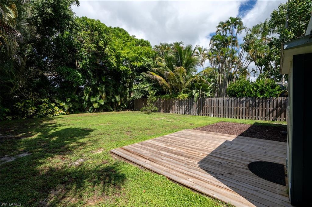 Wooden deck with a fenced backyard