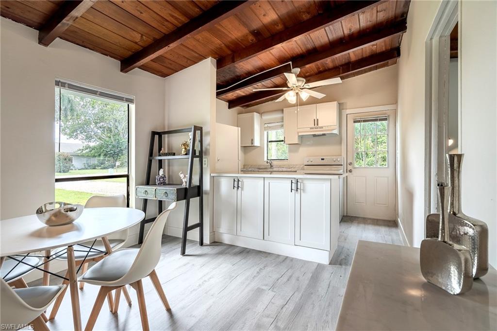 Kitchen with light countertops, white cabinets, white range oven, light wood-type flooring, and wood ceiling