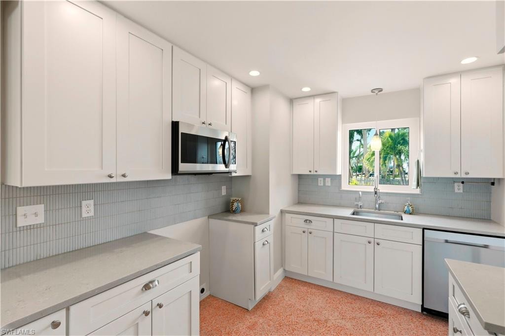 Kitchen featuring a breakfast bar, hanging light fixtures, glass fronted cabinets, a peninsula, and dishwasher