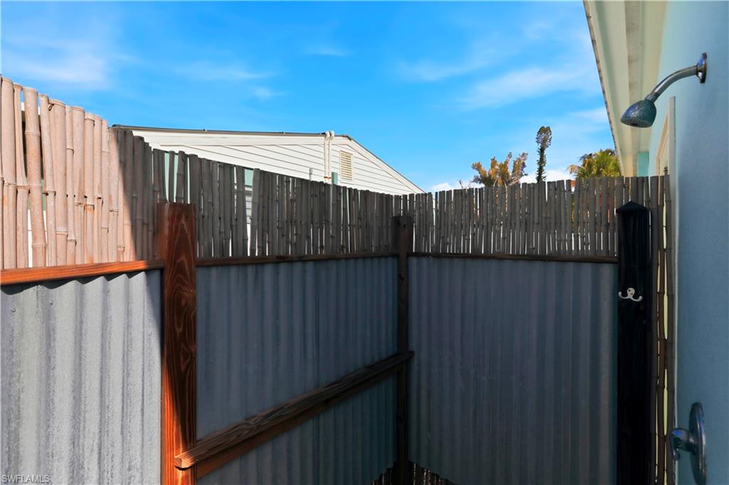Rear view of house with stucco siding and a metal roof
