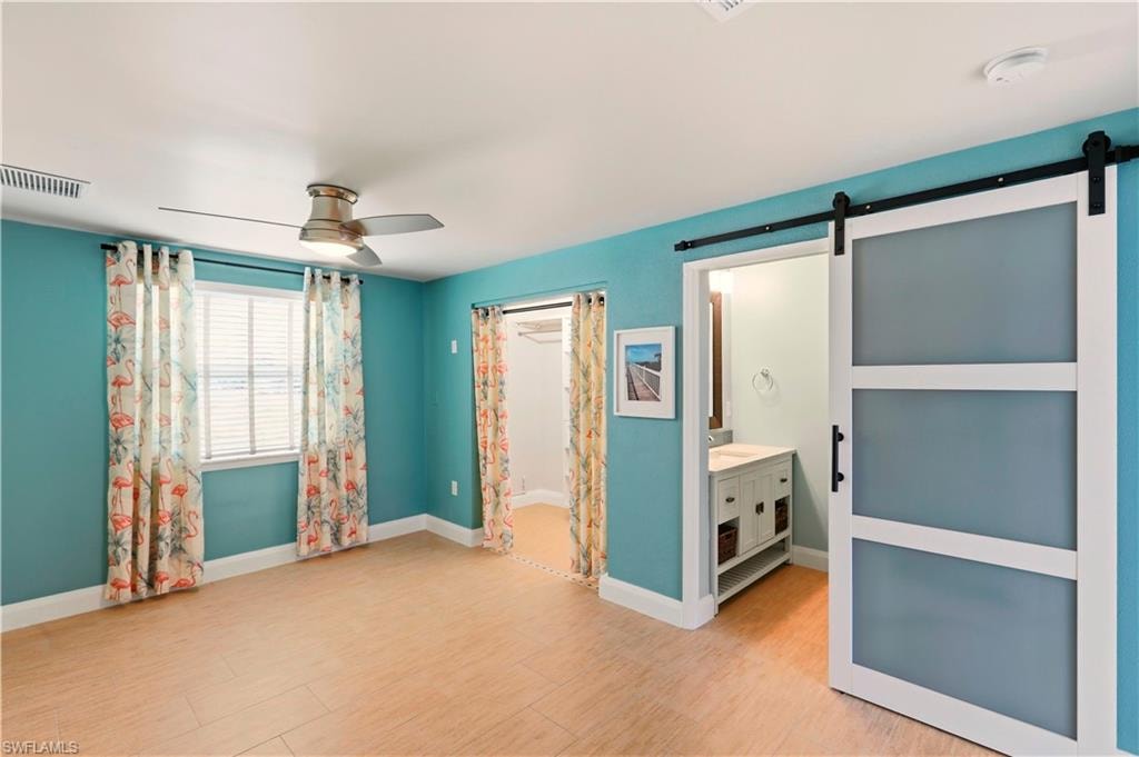 Spare room with a ceiling fan, a wainscoted wall, and a decorative wall