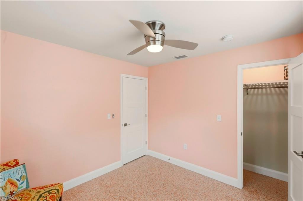 Unfurnished room with baseboards and a ceiling fan