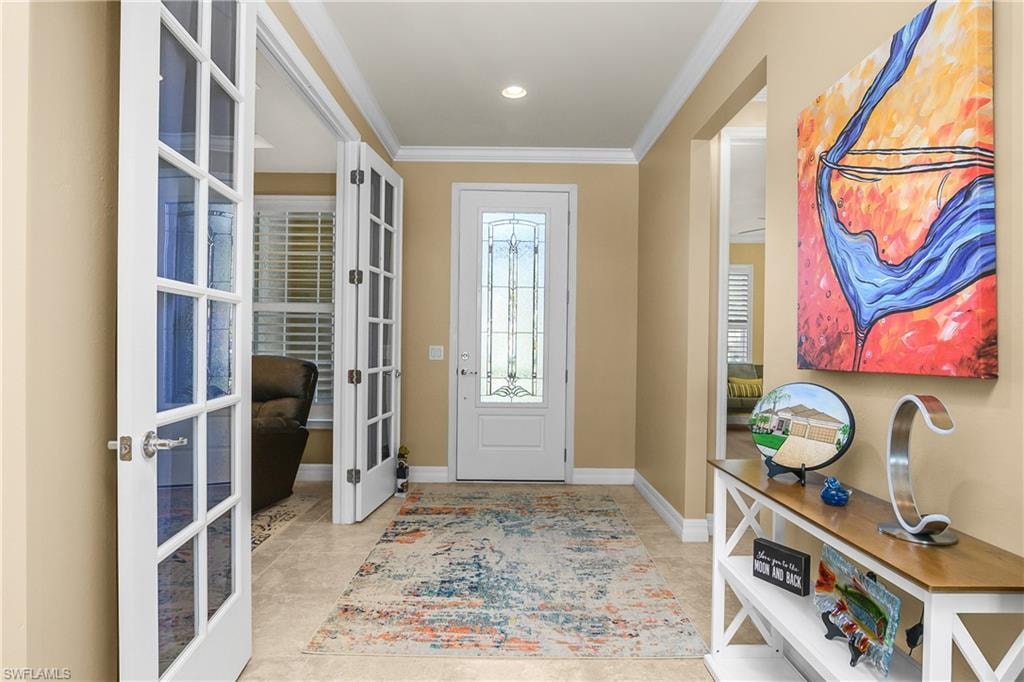 Foyer entrance featuring crown molding and french doors