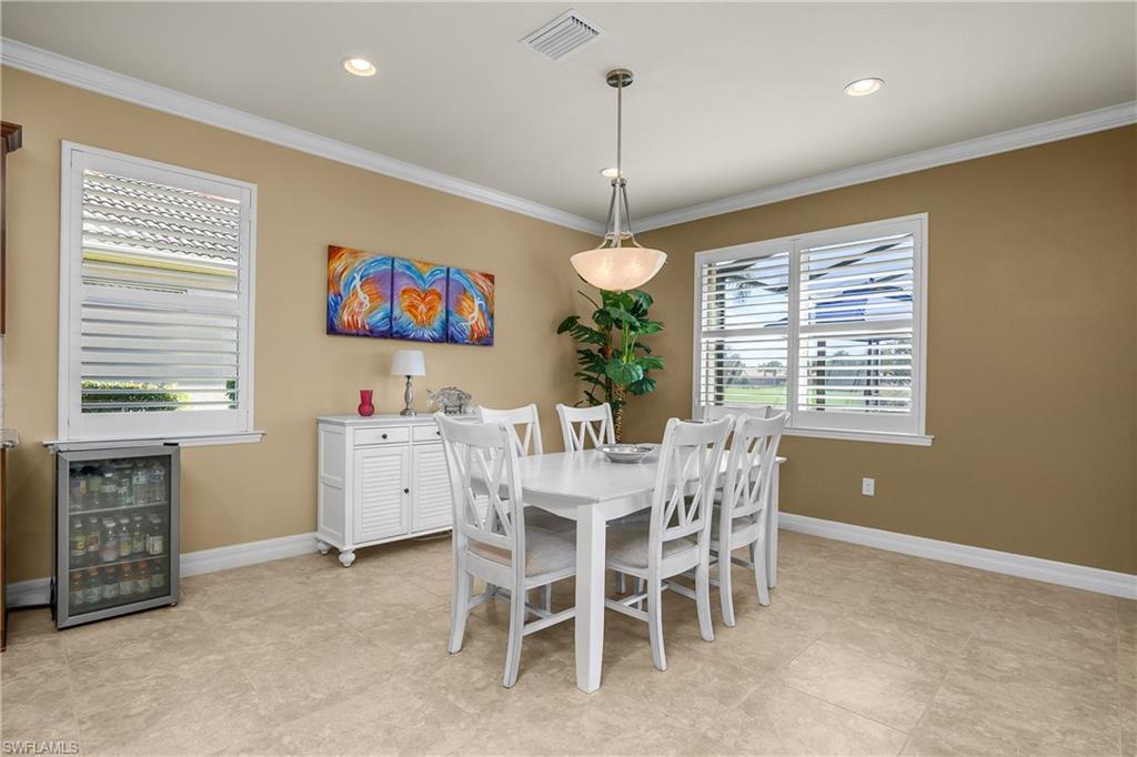 Dining area featuring wine cooler, recessed lighting, and crown molding