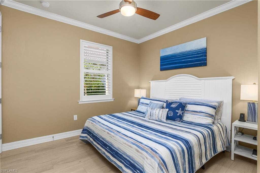 Bedroom with ornamental molding, light wood-type flooring, and ceiling fan
