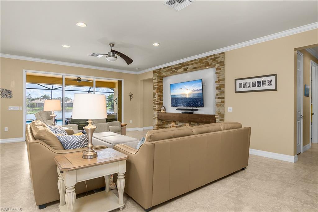 Living area with ceiling fan, ornamental molding, and recessed lighting