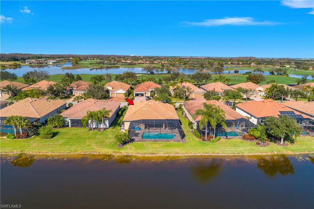 Aerial perspective of suburban area featuring a nearby body of water