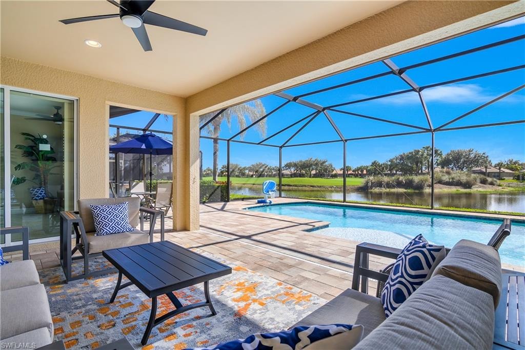 Swimming pool featuring a patio area, a sunroom, a lanai, and a water view
