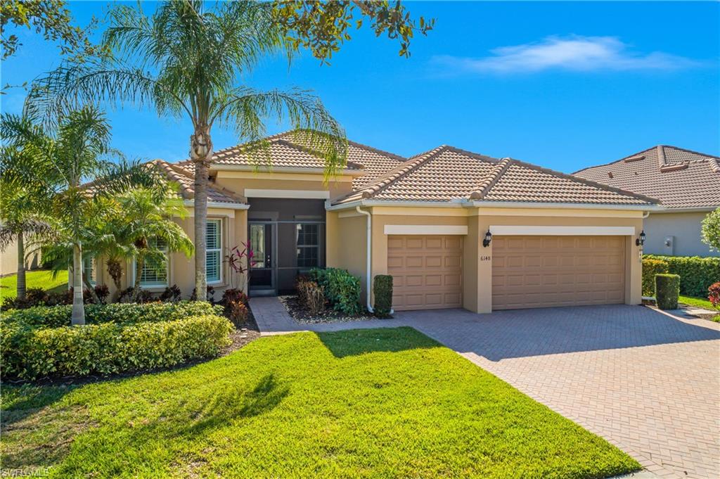 Mediterranean / spanish house featuring stucco siding, an attached garage, decorative driveway, a front yard, and a tile roof