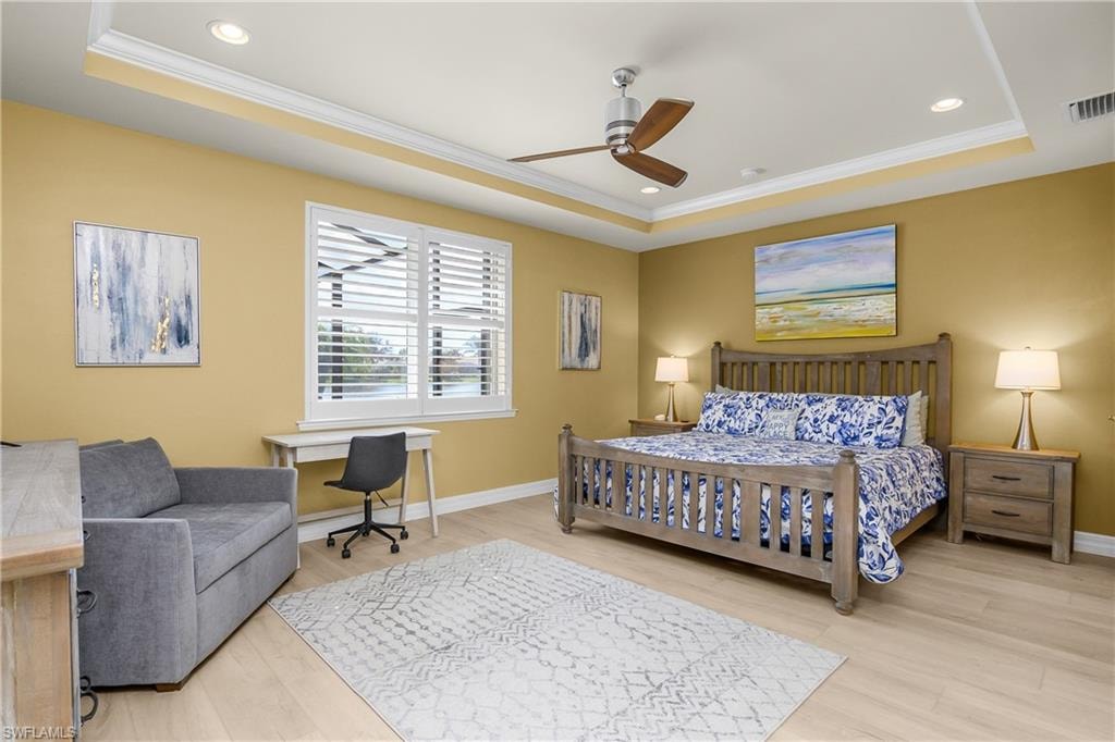 Bedroom featuring light wood finished floors, crown molding, a ceiling fan, an office area, and recessed lighting