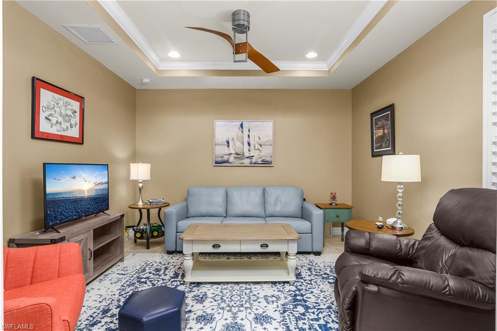 Living area with ceiling fan, recessed lighting, ornamental molding, and a raised ceiling