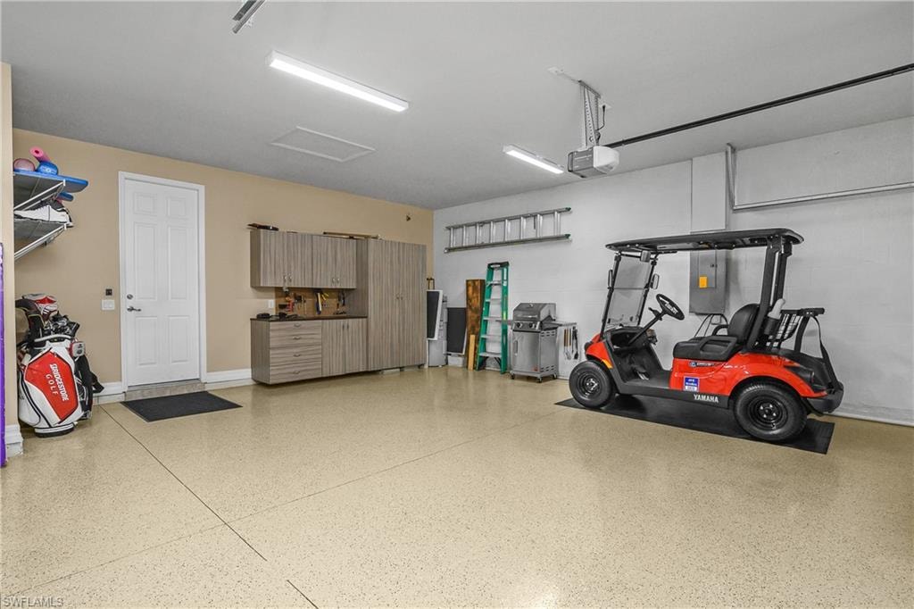 Garage featuring a garage door opener and electric panel