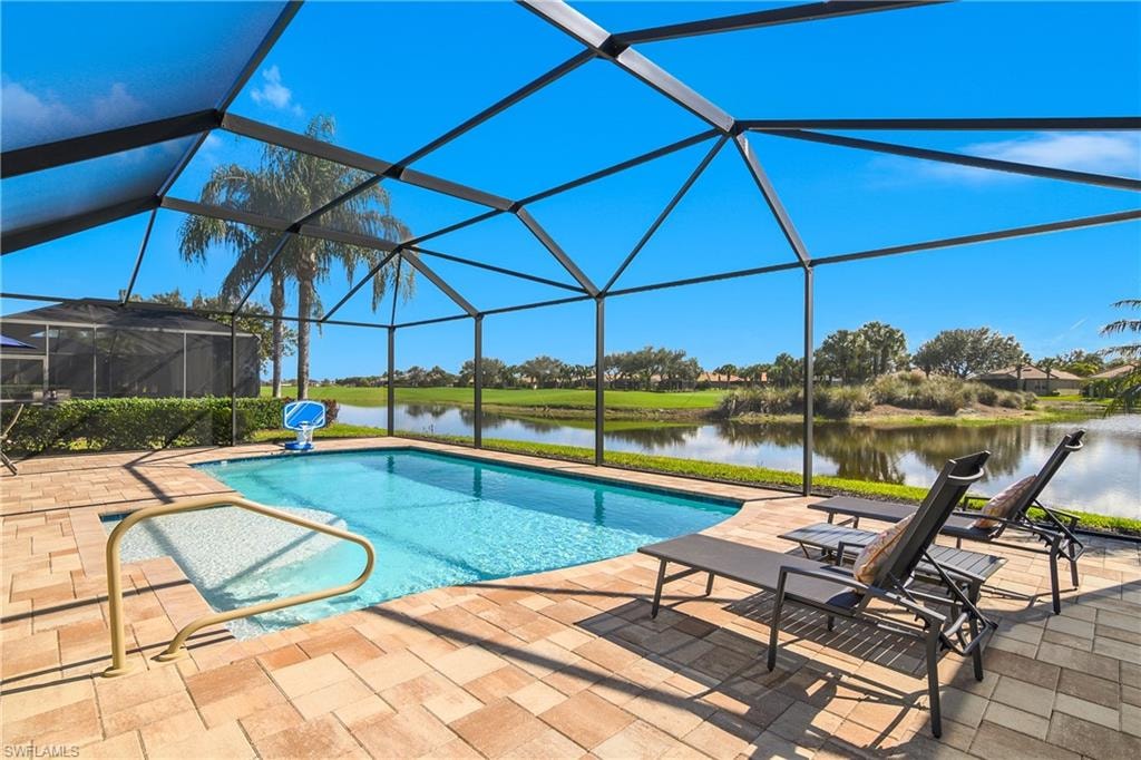 Outdoor pool with a sunroom, glass enclosure, a water view, and a patio area