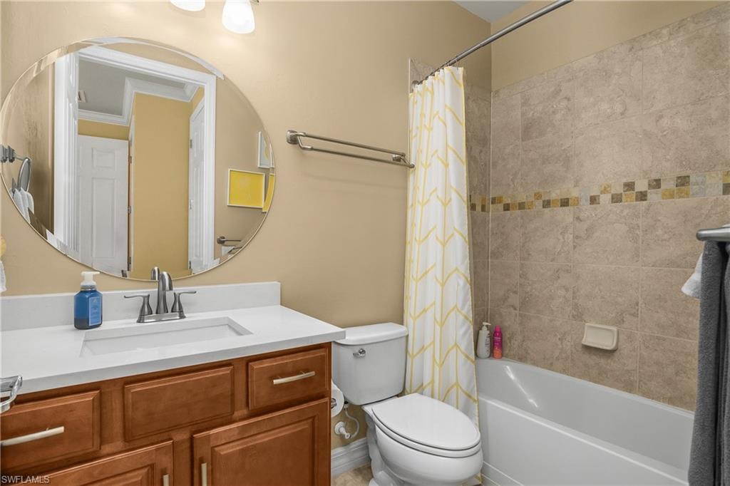 Bathroom featuring vanity and shower / bath combination with curtain