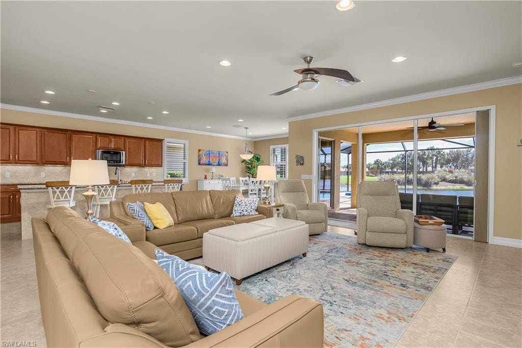 Living room with recessed lighting, ornamental molding, a ceiling fan, and light tile patterned flooring