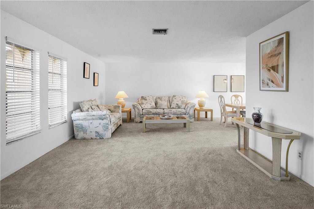 Foyer with double front door entry, opens to the L-shaped living room, has a garage enterance and leads to the family room kitchen area .
