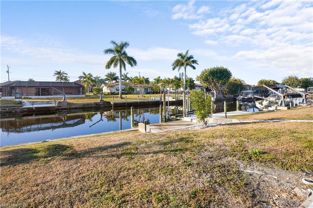 Back of house faces south with a large contrete pool deck area, solar panels to heat your pool, easy access to boat dock and lift.