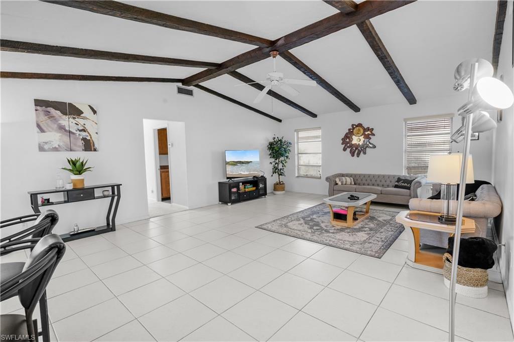 An expansive family room with high vaulted ceilings is open to the kitchen and opens to the covered lanai, pool, and Gulf access canal.