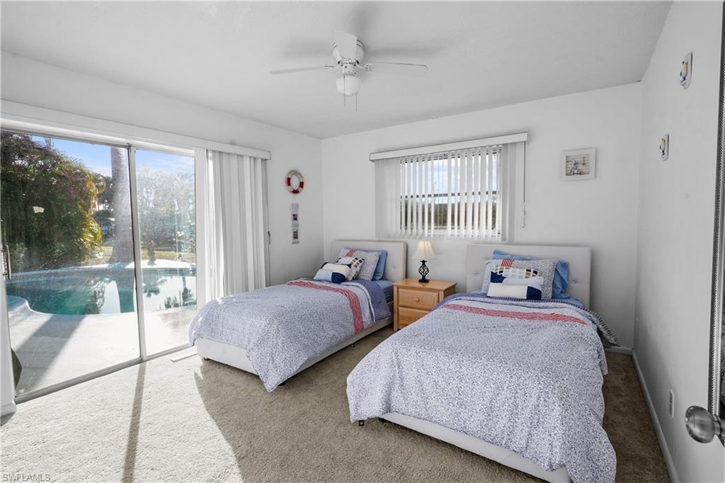 Bedroom featuring light carpet, ceiling fan, and a large reach-in closet.