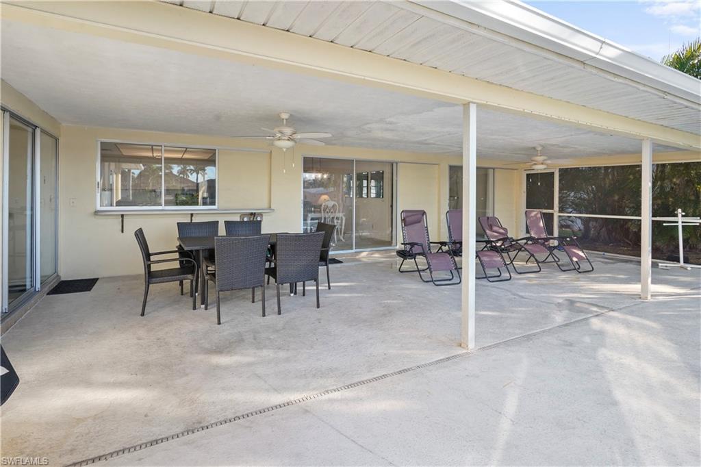 View of covered lanai over looking the pool, a ceiling fan, outdoor dining area faces south. Will be wonderful to enjoy your pool time!