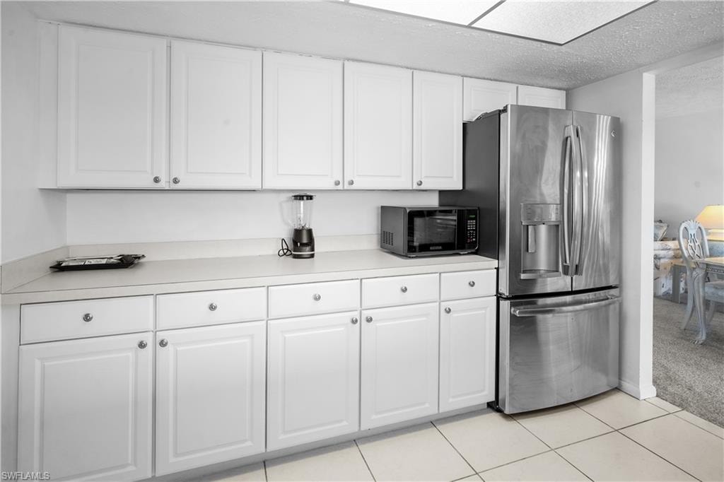 Kitchen featuring stainless steel appliances, white cabinets, light neutral colored finishes for flexible decorating.