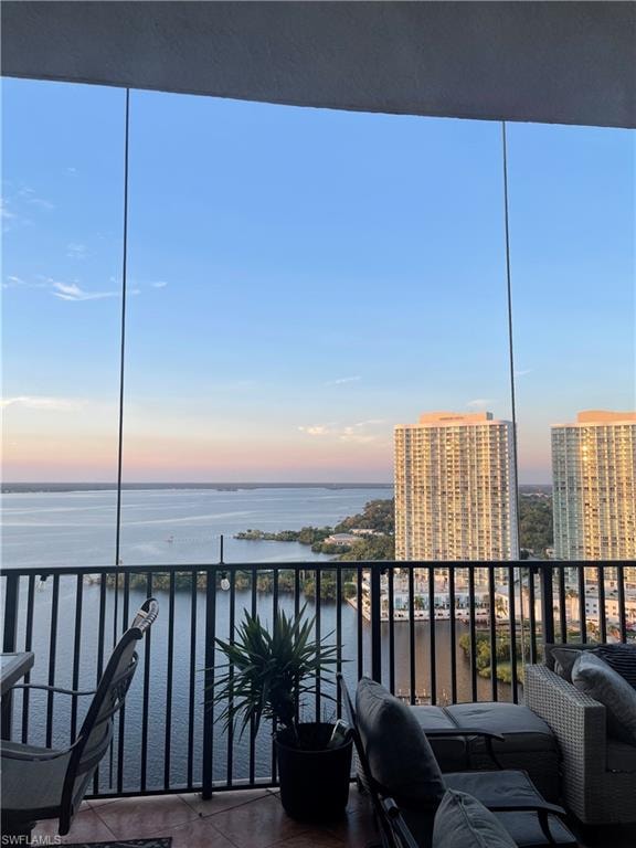 Balcony at dusk featuring a water view