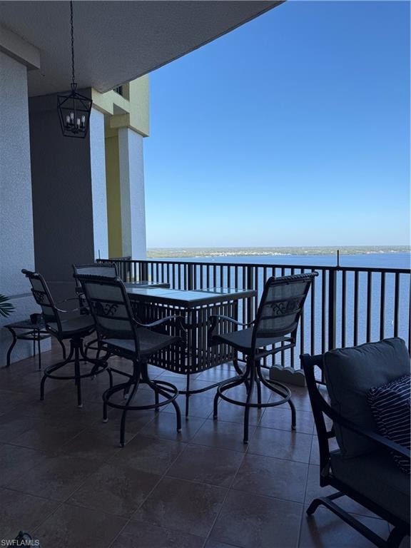 Balcony featuring outdoor dining area and a water view
