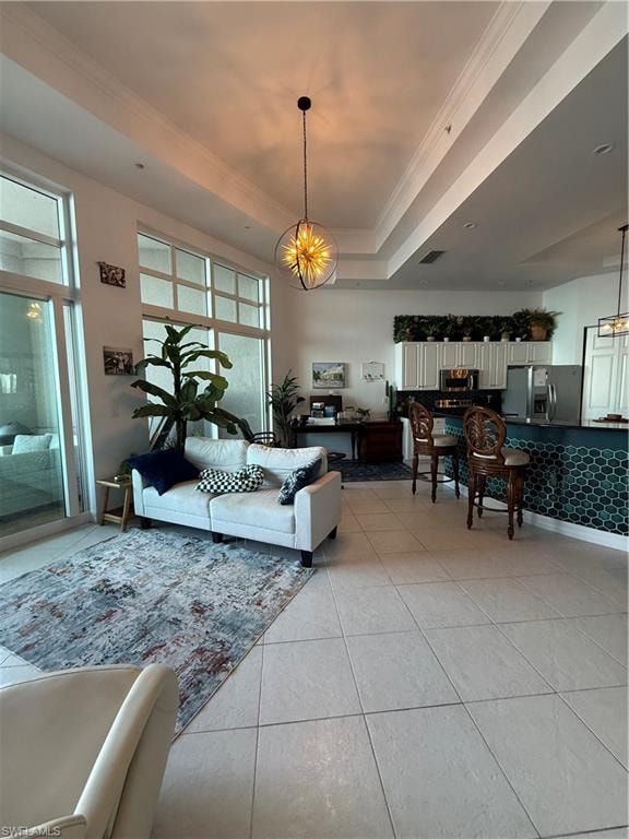 Living area featuring crown molding, a raised ceiling, light tile patterned floors, and a chandelier