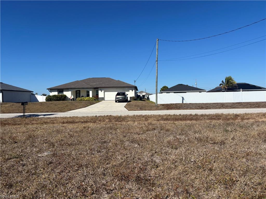 View of yard with concrete driveway and an attached garage