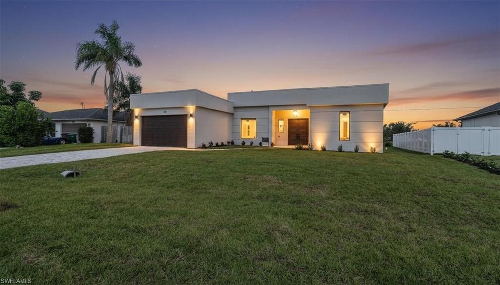 Contemporary home featuring driveway, a garage, and stucco siding