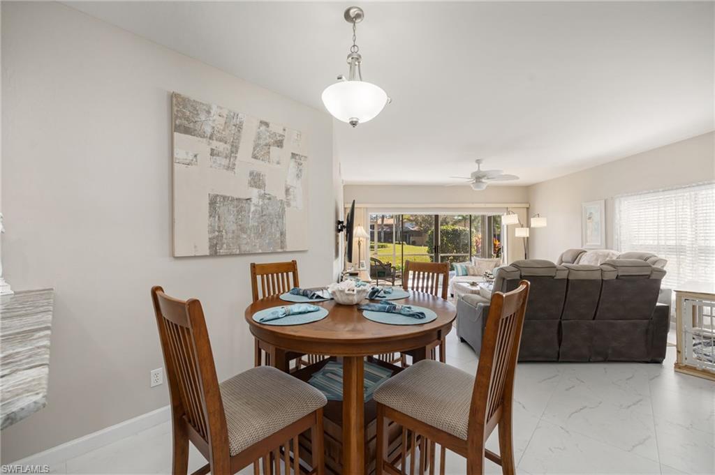 Dining room with marble look tiles and a ceiling fan