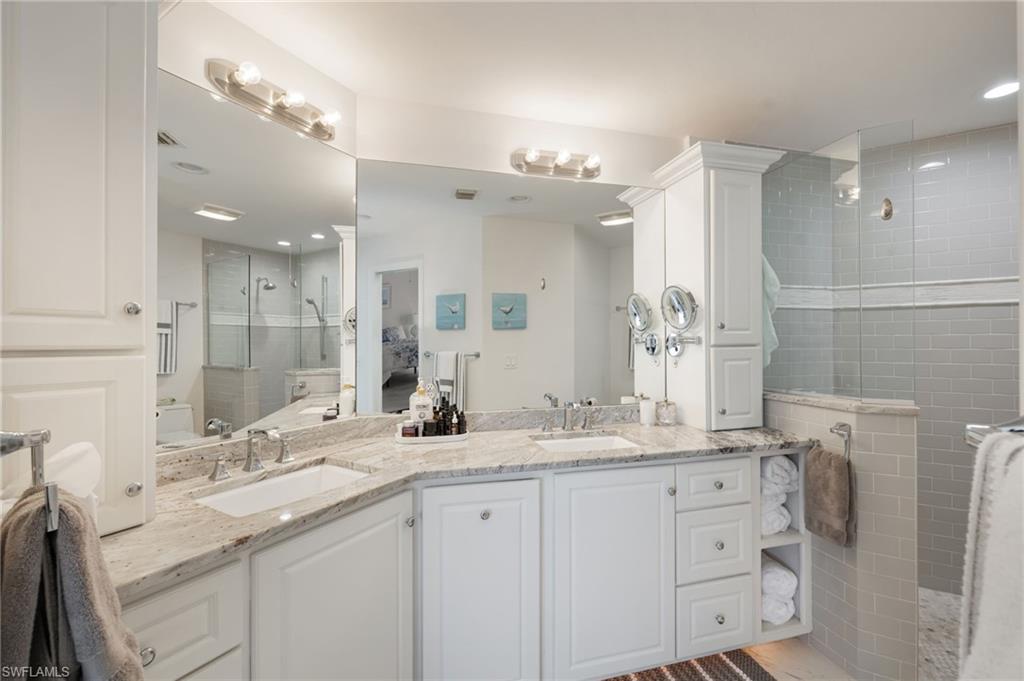 Full bath featuring double vanity, walk in shower, and recessed lighting