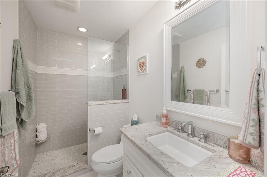 Bathroom featuring vanity, a walk in shower, and recessed lighting