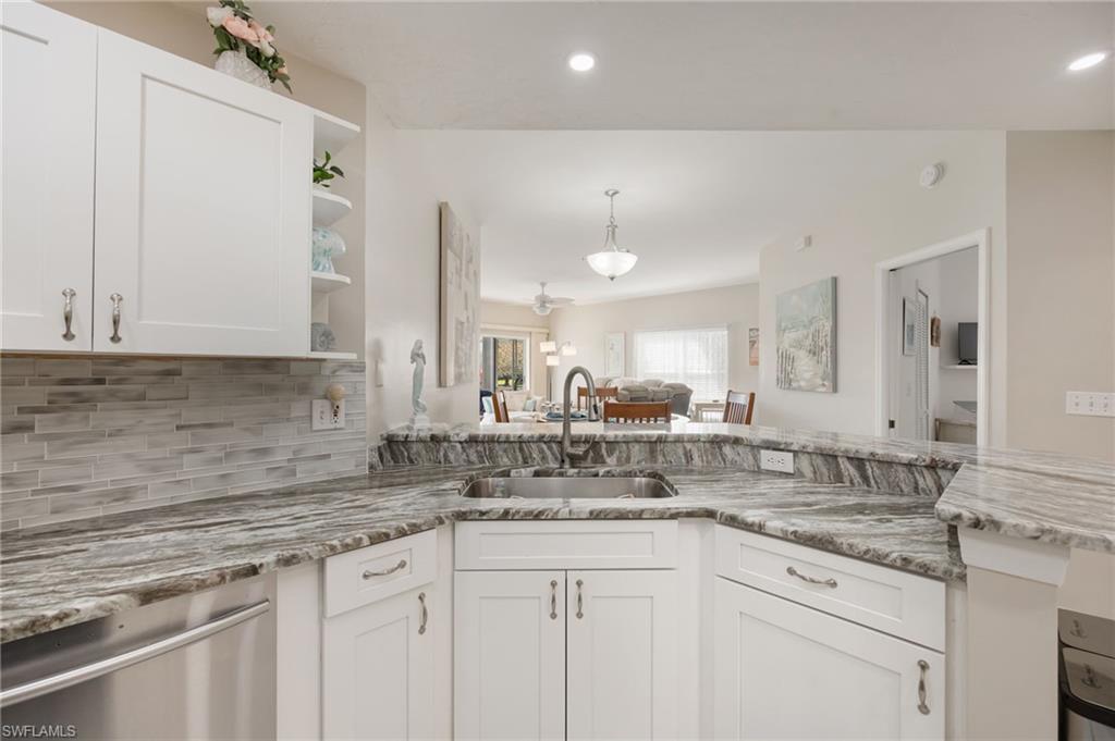 Kitchen with open shelves, white cabinetry, dishwasher, pendant lighting, and open floor plan