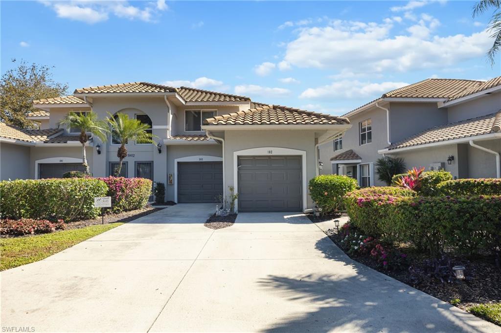 Mediterranean / spanish-style house with driveway, stucco siding, an attached garage, and a tiled roof