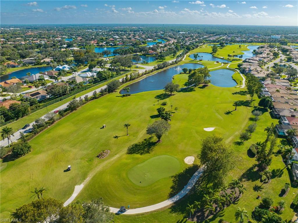 Aerial perspective of suburban area with a golf course and a nearby body of water