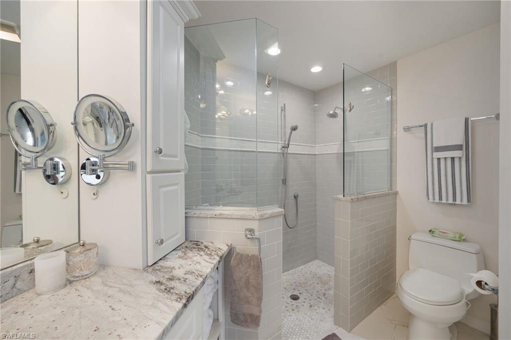 Bathroom featuring a walk in shower, vanity, and recessed lighting
