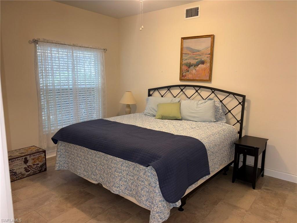 Spacious room featuring tile flooring, neutral wall tones, and a window with blinds