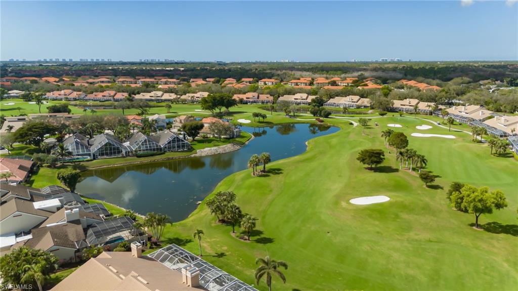 Aerial view of residential area with a nearby body of water and a golf club