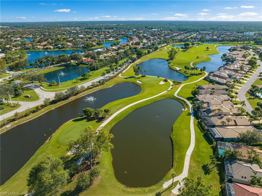 Aerial perspective of suburban area featuring a golf club and a large body of water