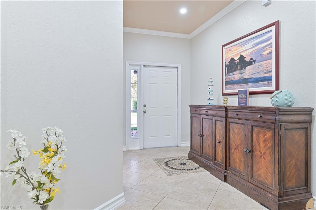 Foyer featuring crown molding, light tile patterned floors, and recessed lighting